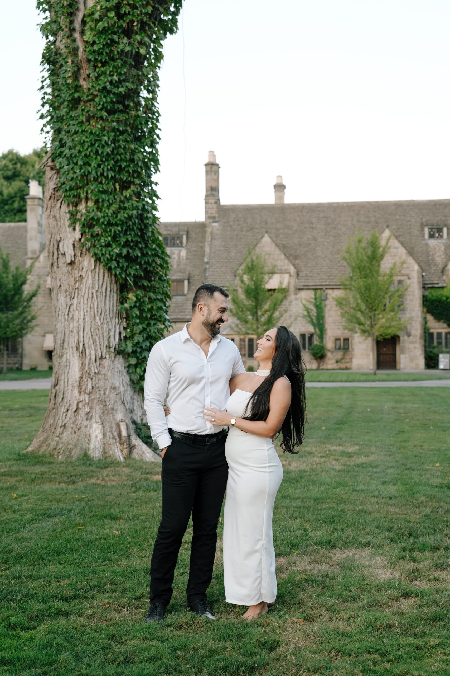 Couple sharing a joyful moment outdoors near a rustic building.
